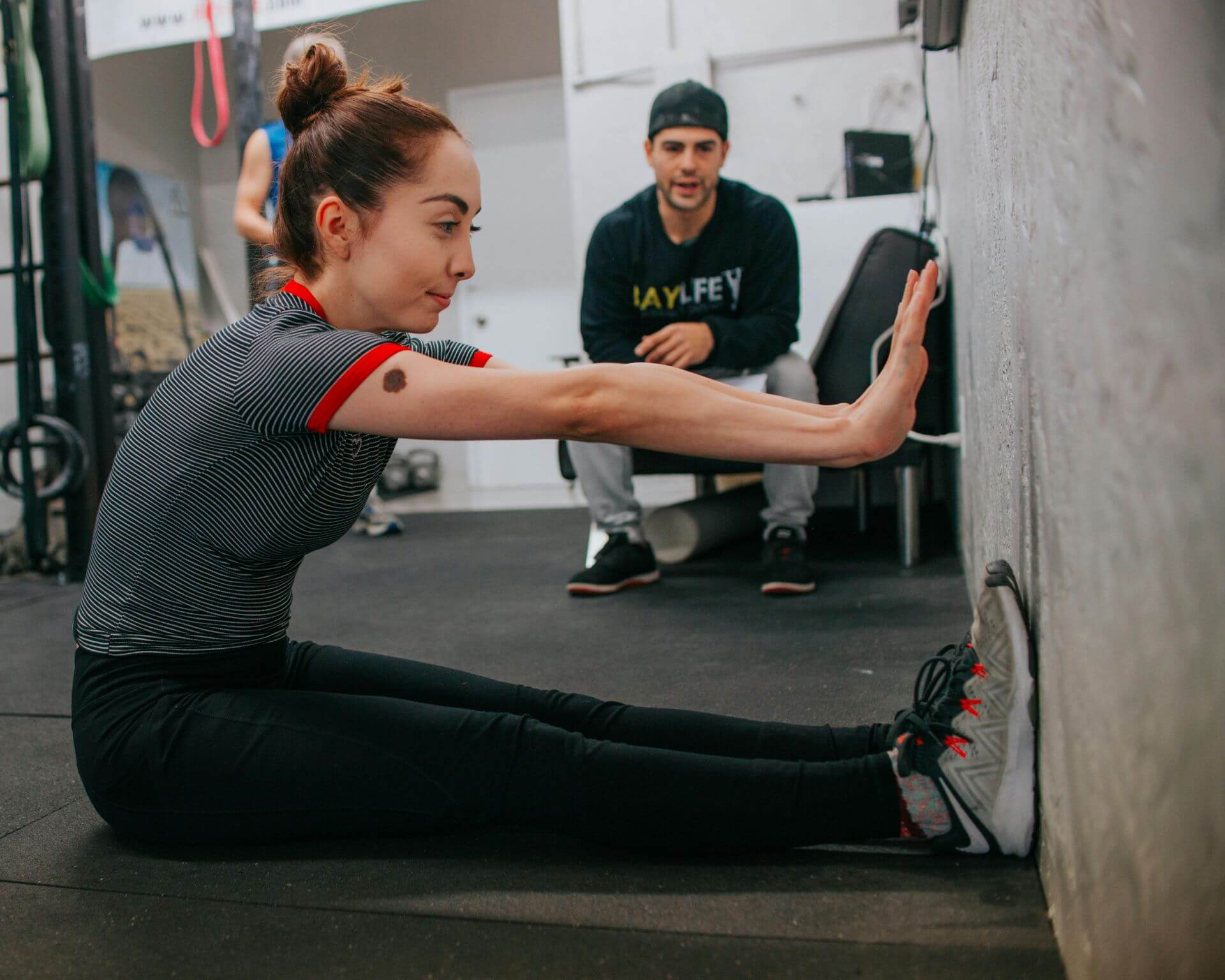 Personal training guiding a woman to stretch properly