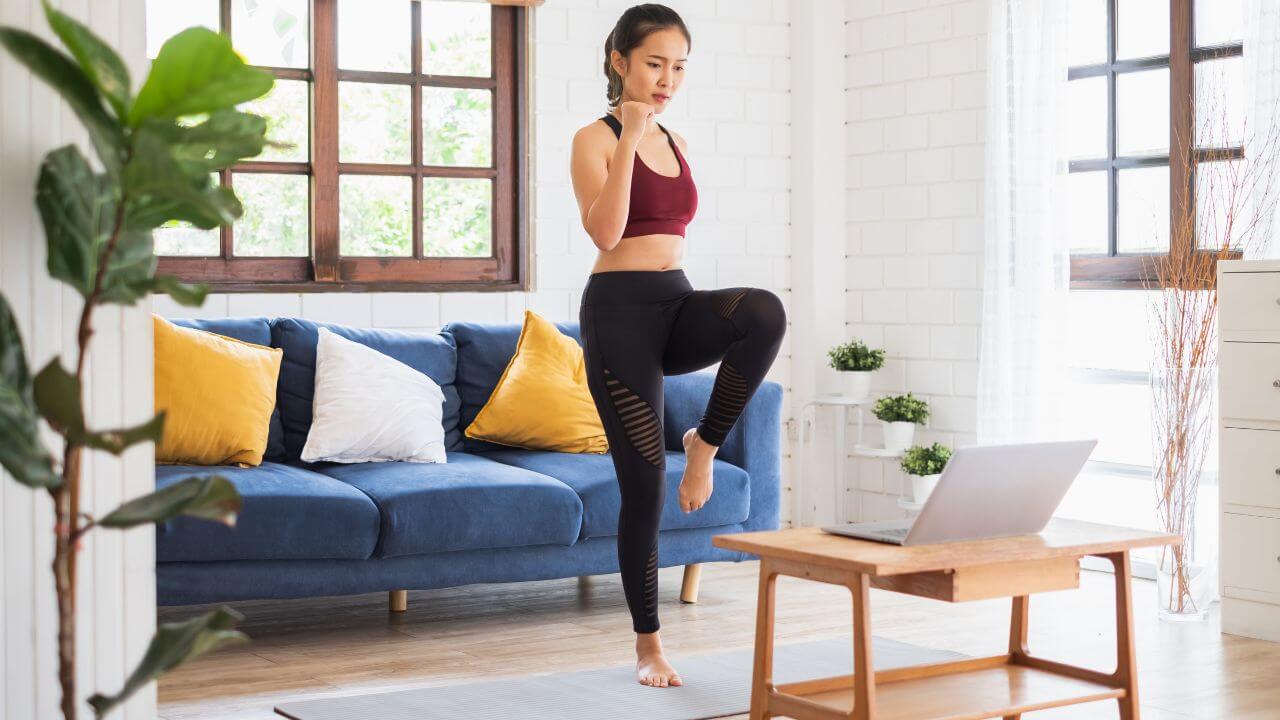 Woman exercising at home with online health and fitness coaching