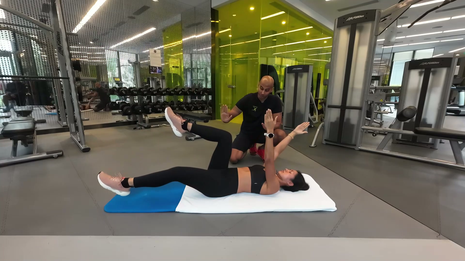 Phyzique client doing floor exercises with coach